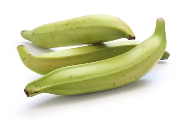 Cachos de banana-pão frescos numa caixa de madeira